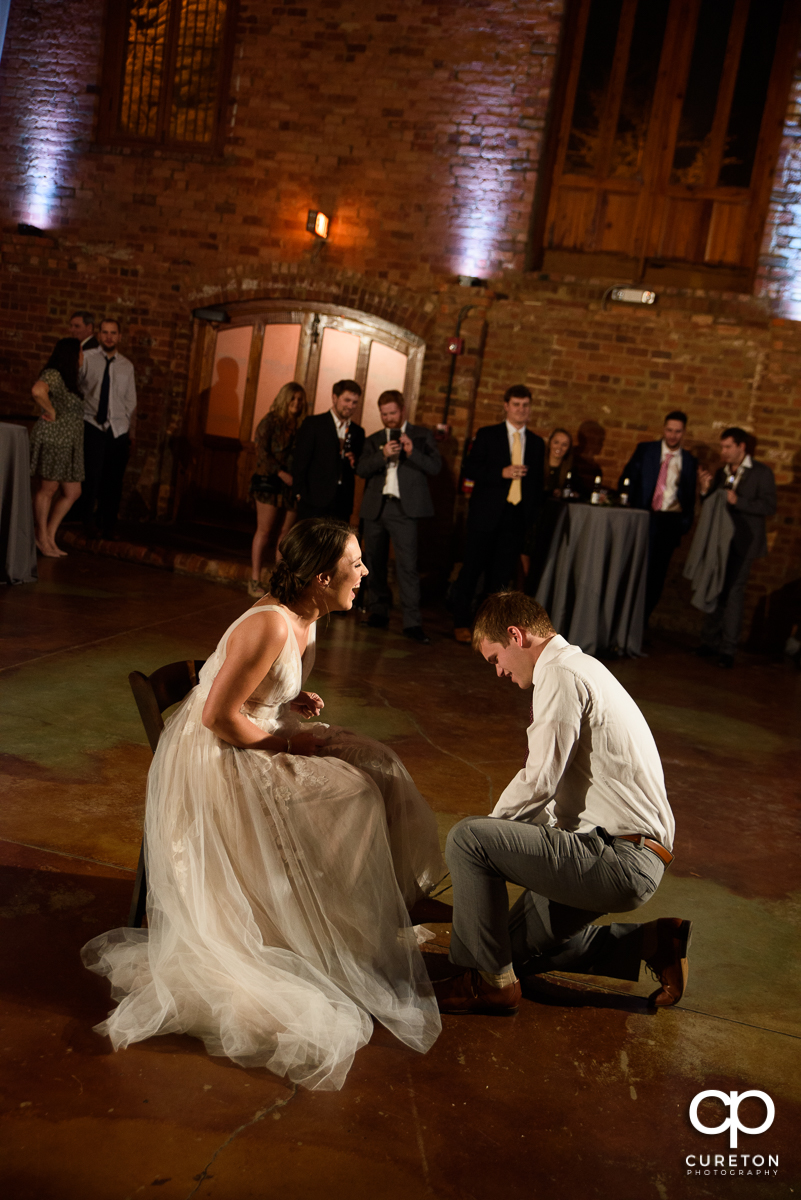 Groom taking off the garter.