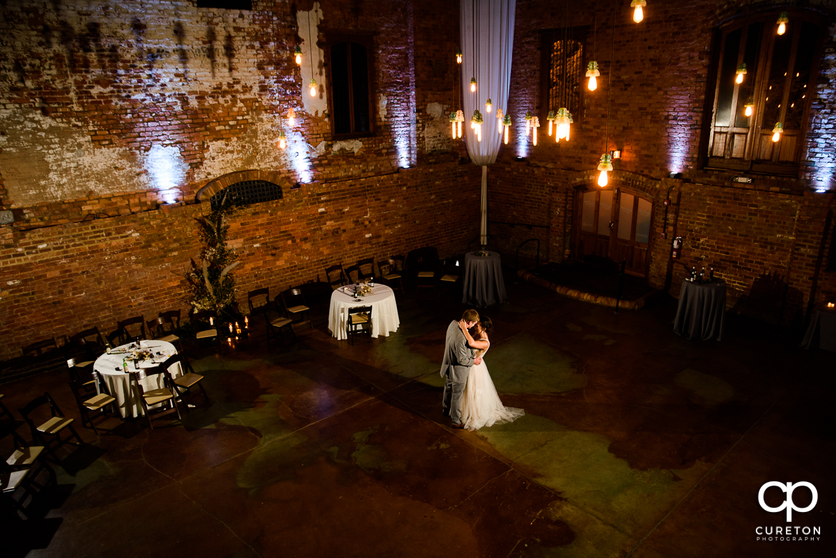 Bride and groom sharing a private dance at the wedding reception in the main hall of the Old Cigar Warehouse.