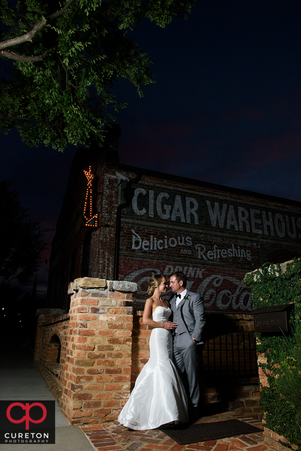 Bride and Groom standing underneath the sign at The Old Cigar Warehouse.