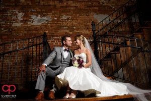 Married couple sitting on the steps of The Old Cigar Warehouse.