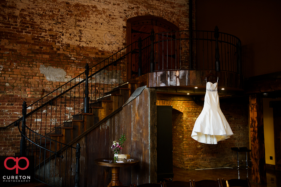 The bride's dress hanging on the staircase.