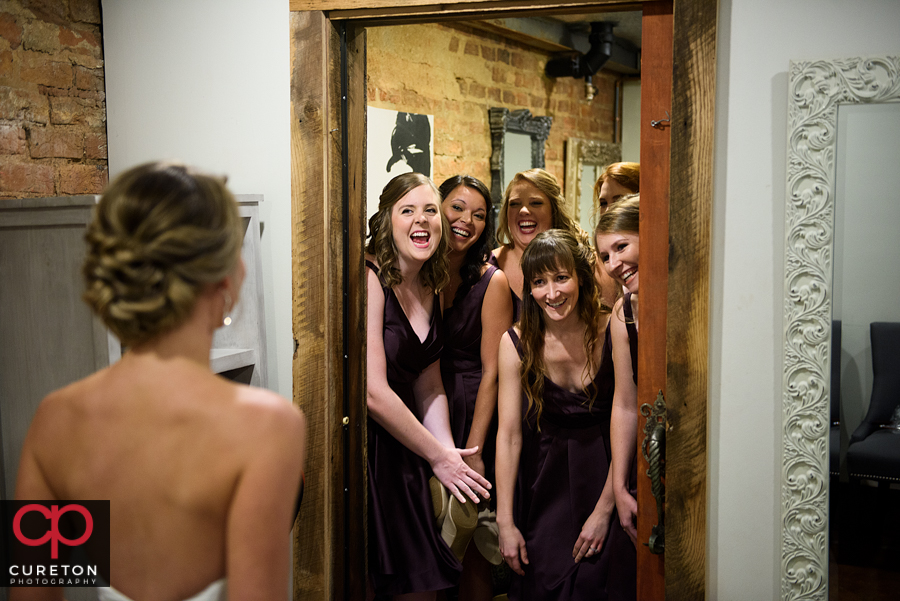 The bridesmaids seeing the bride for the first time.