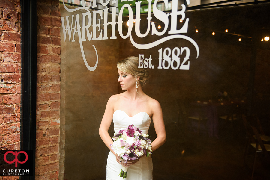 A bride looking through the window at the Old Cigar Warehouse.