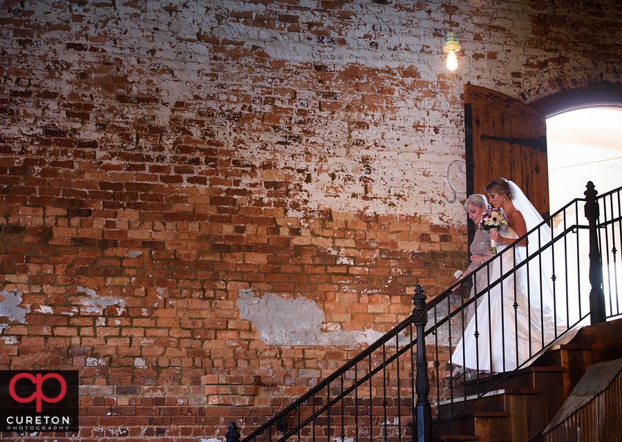 Bride and her mom walking down the stairs at Old Cigar Warehouse.