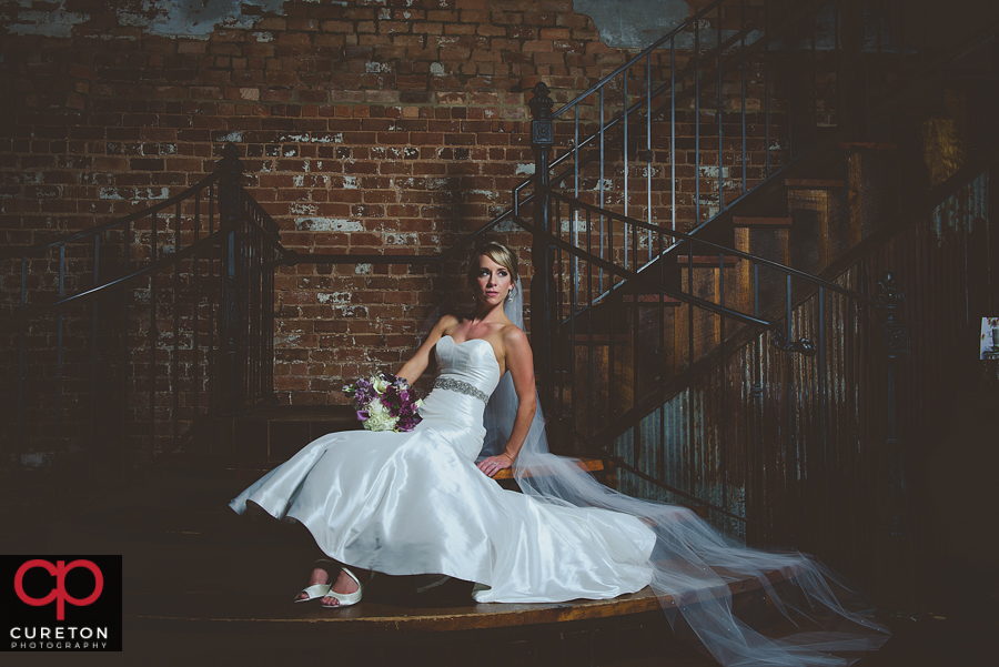 Bride sitting on the steps at The Old Cigar Warehouse.
