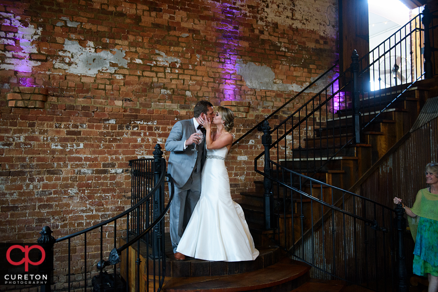 Bride and groom kissing on the steps.