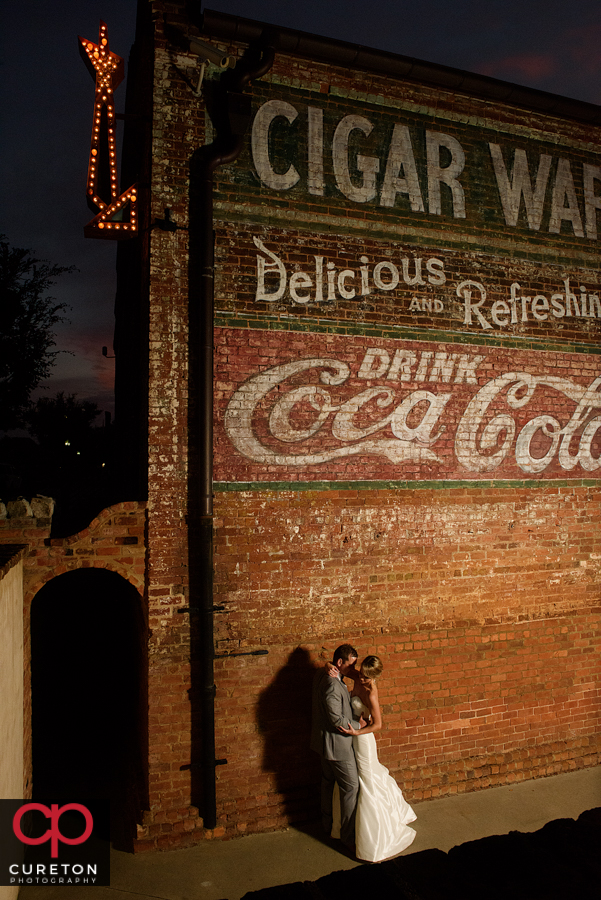The bride and groom at night in front of The Old Cigar Warehouse.