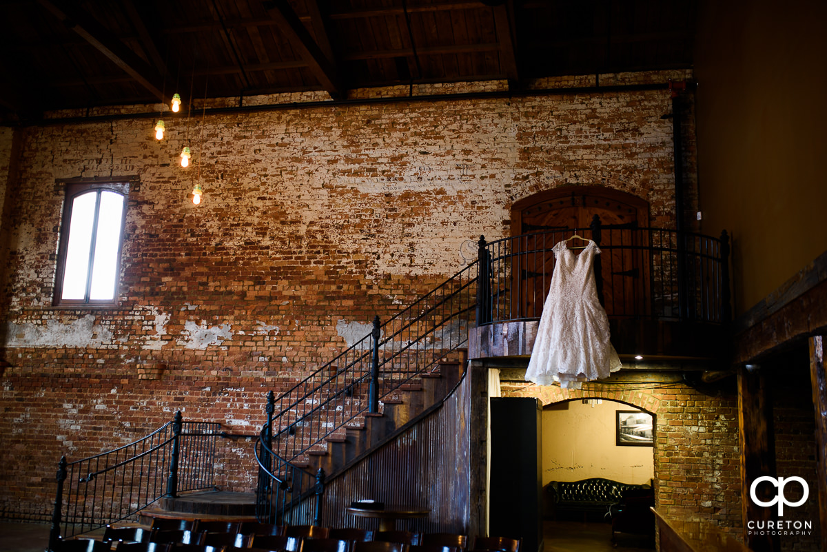 Wedding dress hanging on the staircase at Old Cigar Warehouse.