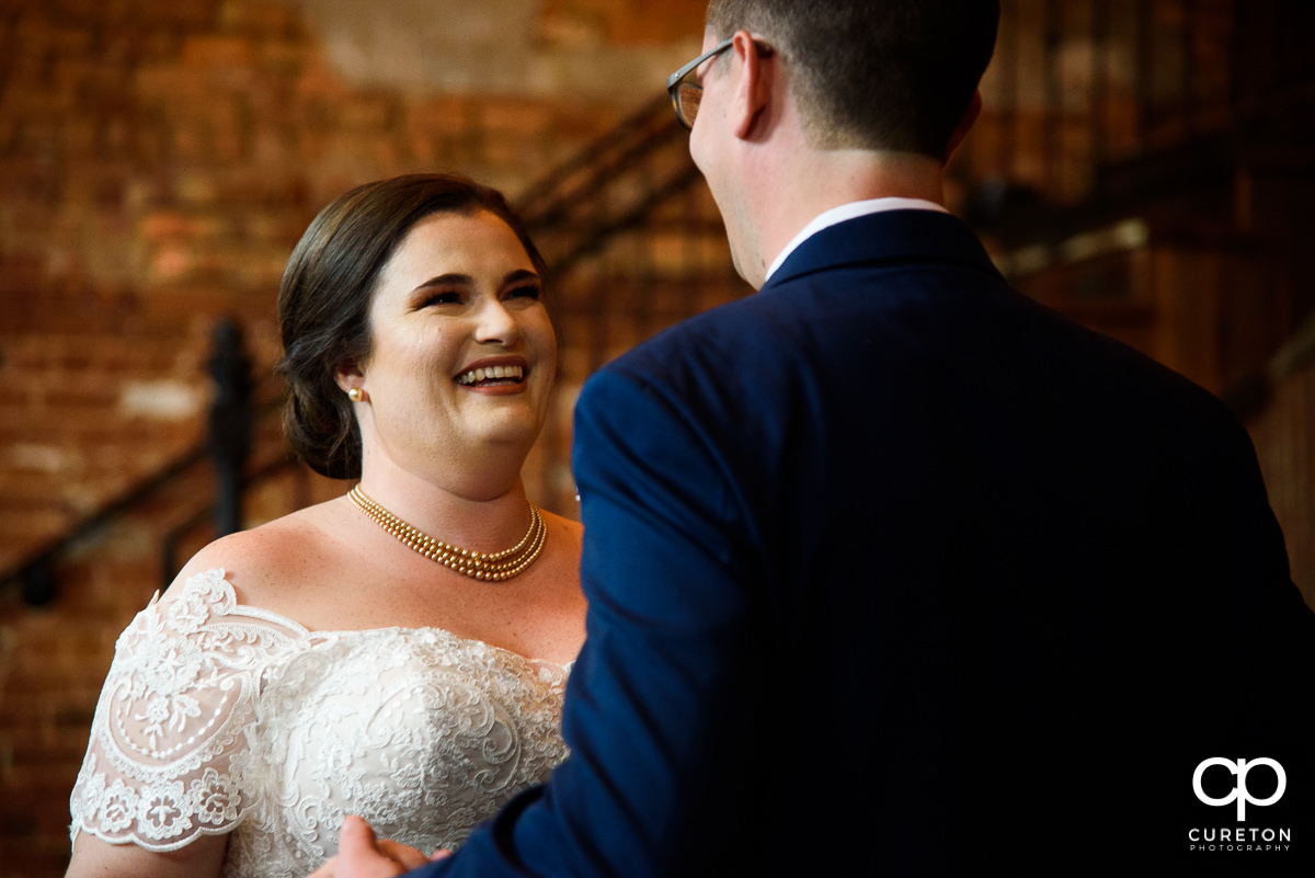 Bride smiling at her groom at a first look before the wedding ceremony.
