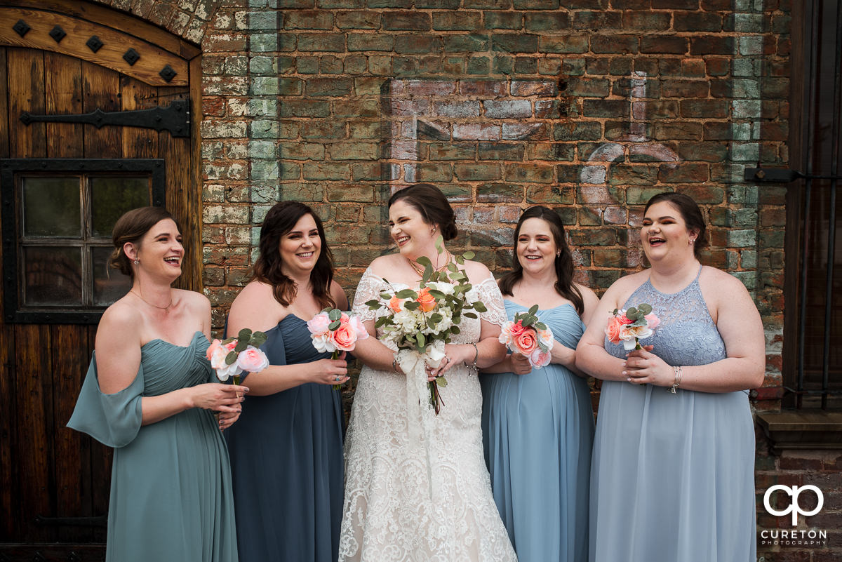 Bride laughing with her bridesmaids on the deck of The Old Cigar Warehouse.