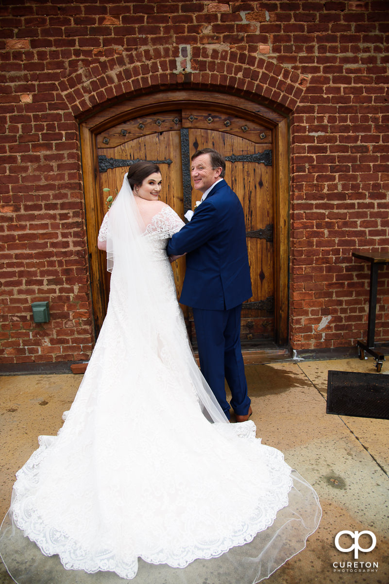 Bride and her father getting ready to walk down the staircase.