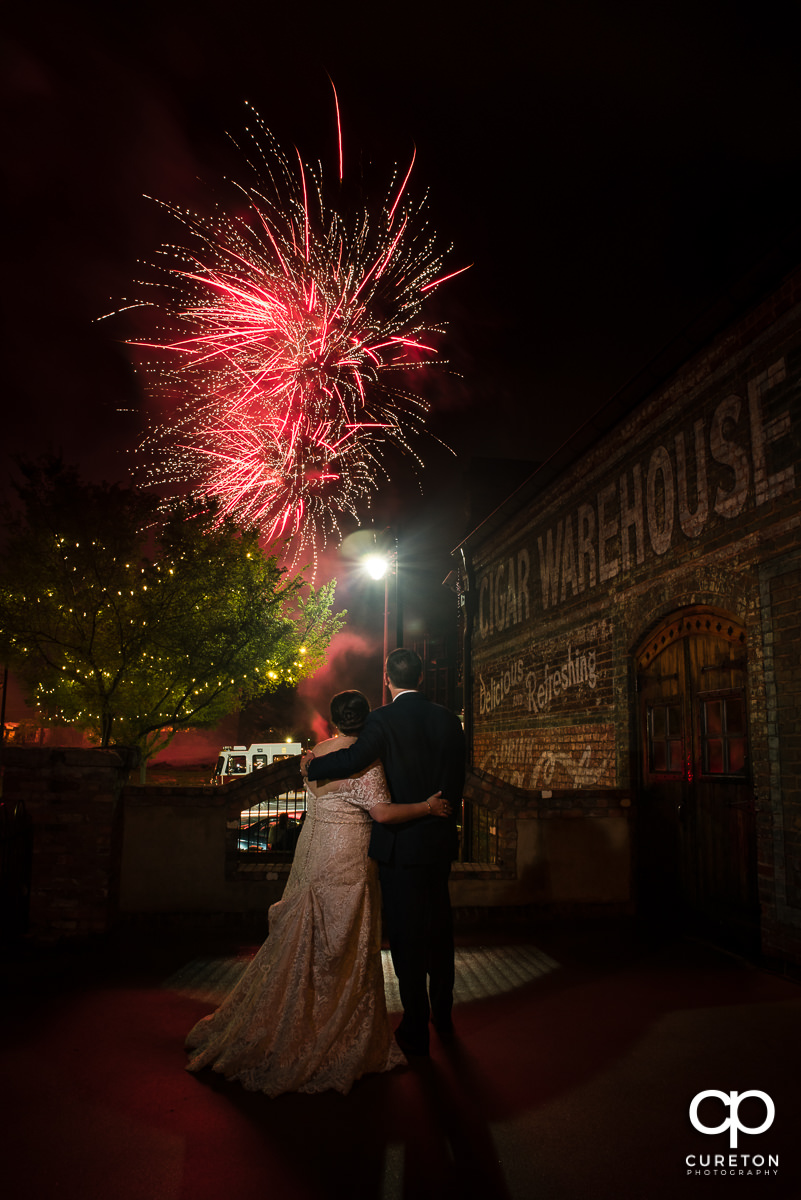 Bride and groom watching the Greenville Drive's fireworks from the deck of the Old Cigar Warehouse