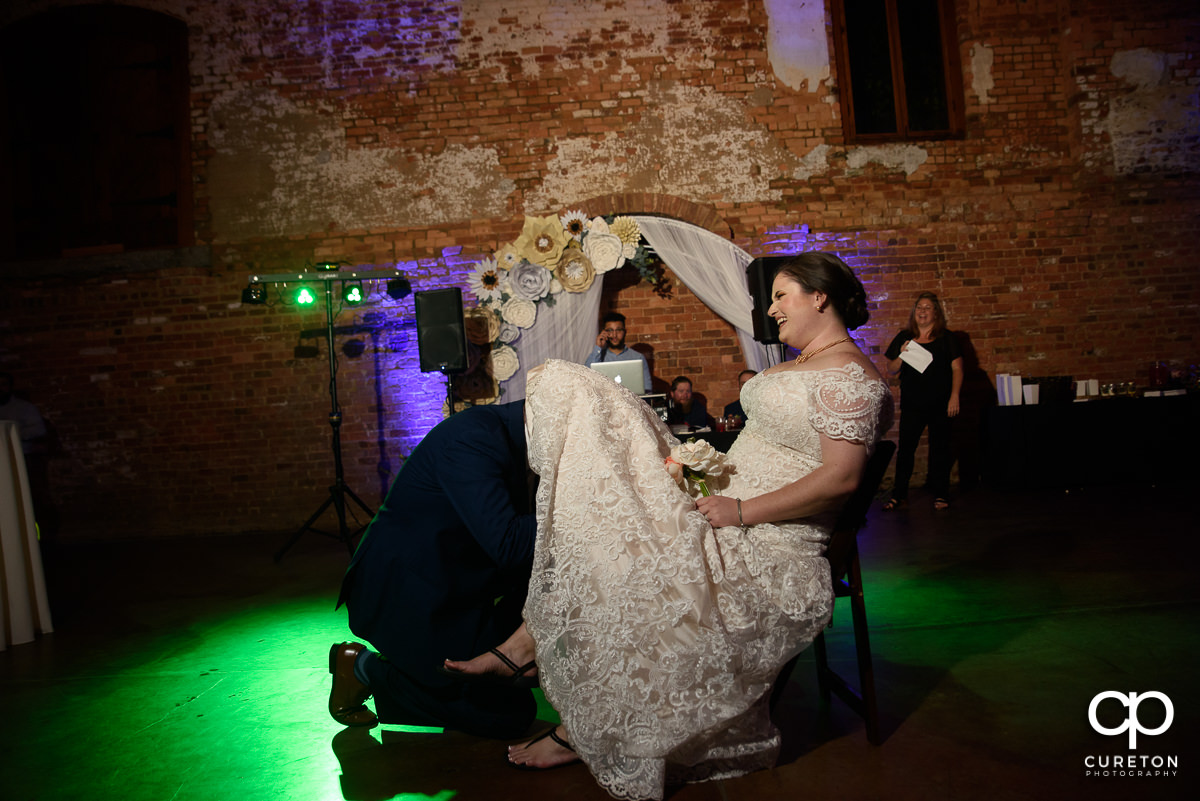 Groom taking off the bride's garter.