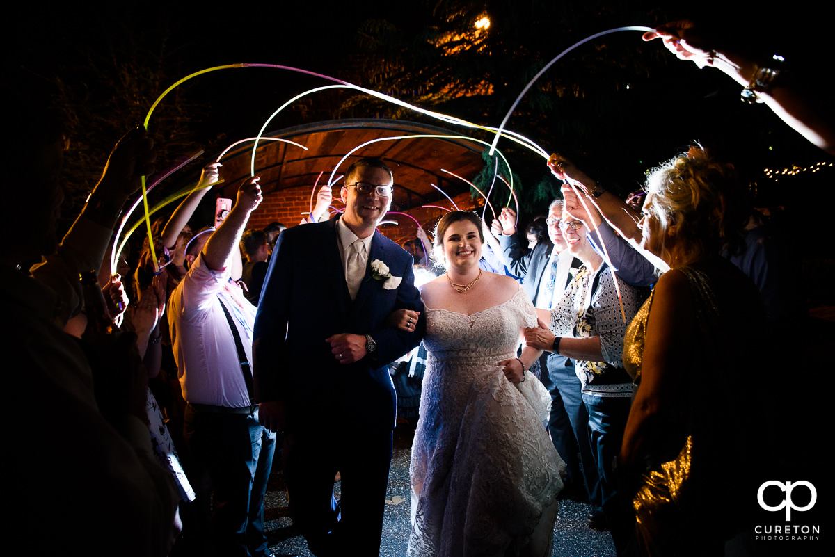 Bride and groom making a grand exit though glow sticks at The Old Cigar Warehouse wedding.