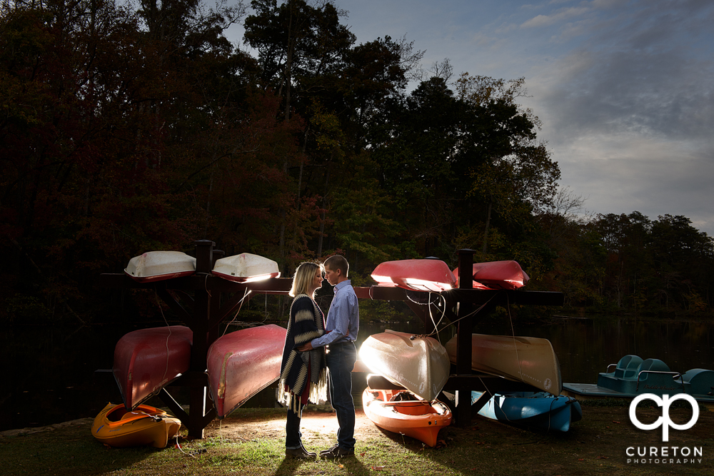 Couple standing by the boats near the lake during their Paris mountain engagement session in Greenville South Carolina.