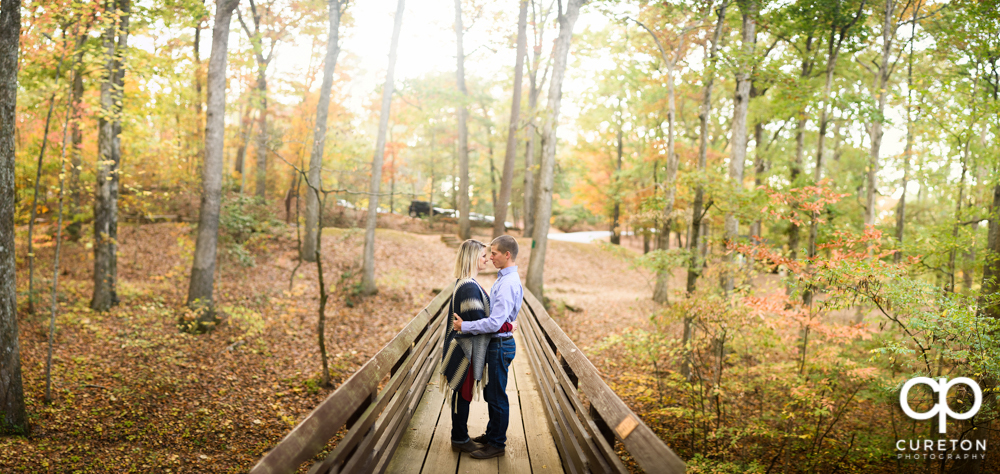 Future bride and groom standing on the bridge during their Paris mountain engagement session.