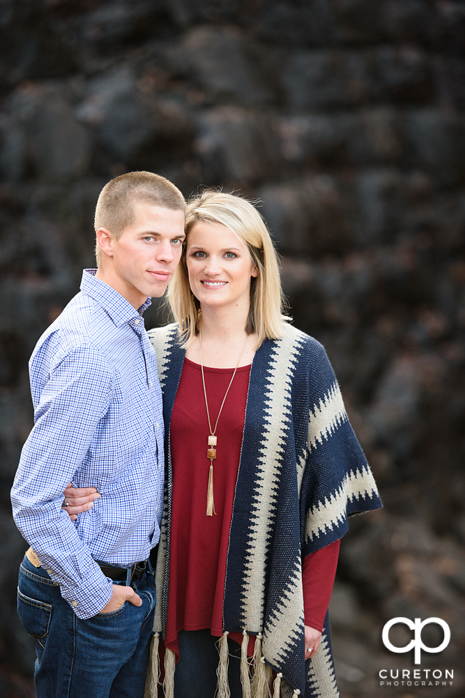 Future bride and groom standing in front of the falls at the park.