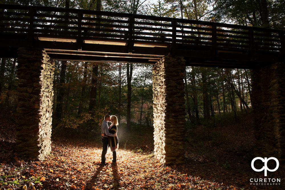 Epic photo of a future bride and groom under the bridge during their Paris mountain engagement session.