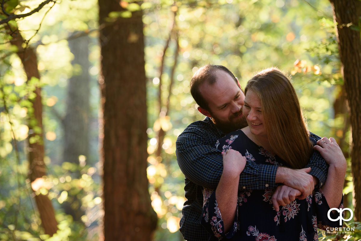 Future bride and groom laughing during their engagement session at Paris Mountain State Park in Greenville,SC.