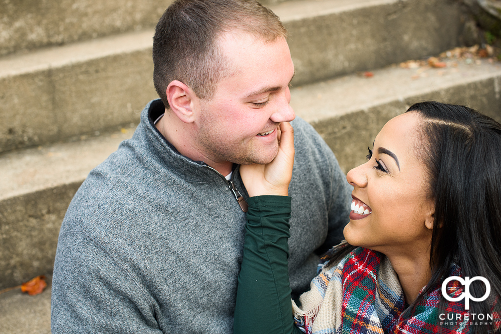 Engaged couple smiling at each other.