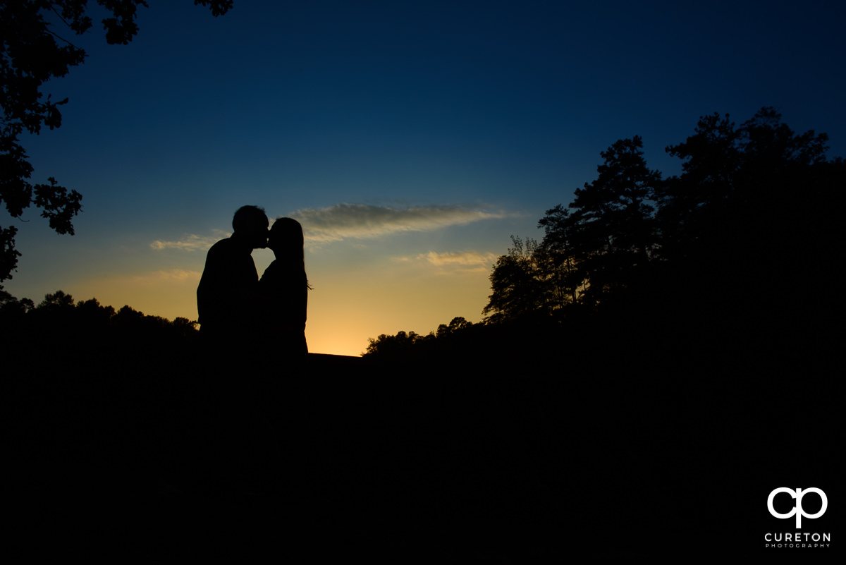 Sunset silhouette of an engaged couple at Paris Mountain State Park.