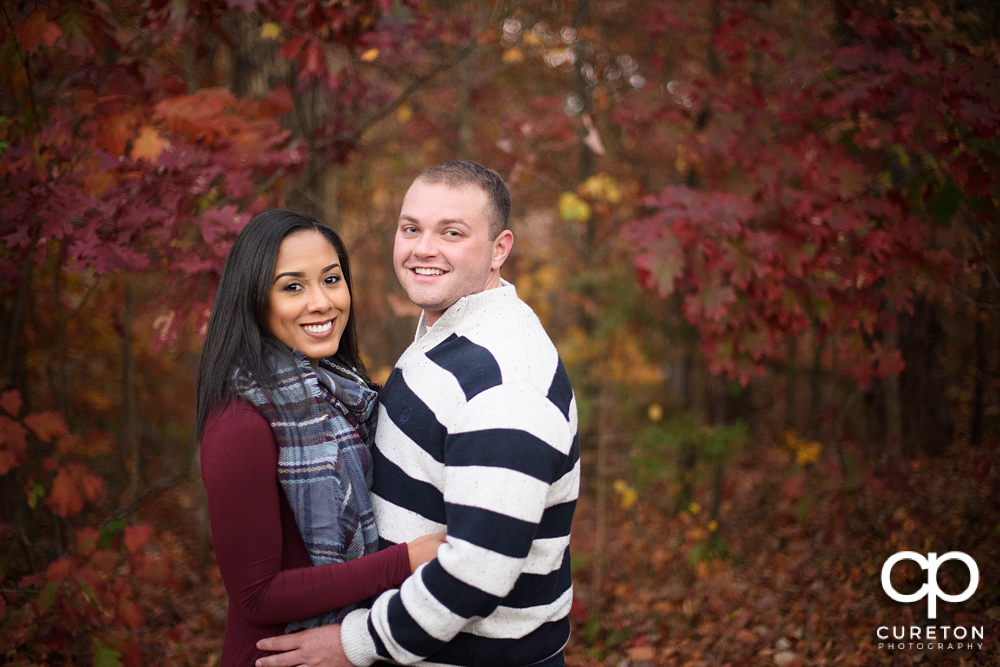 Engaged couple with a beautiful fall leaf background.