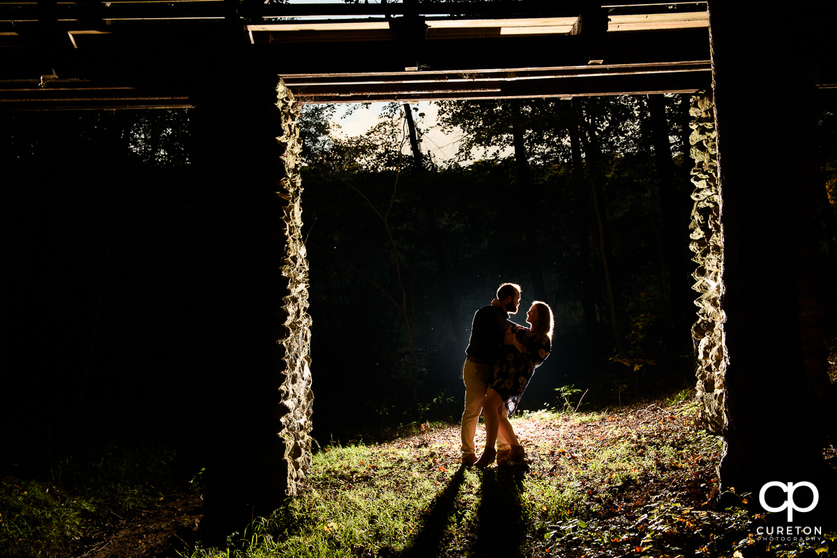 Engaged couple dancing in the woods.