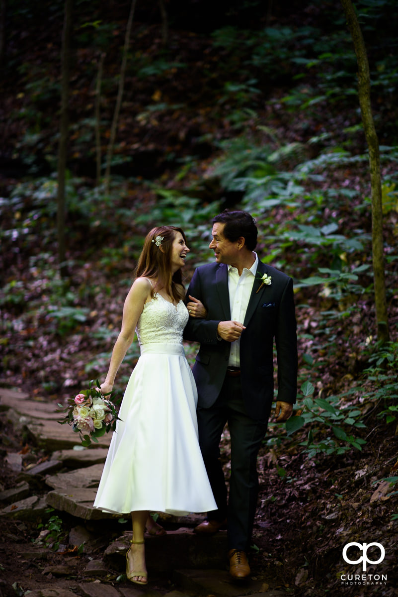 Bride and groom strolling though the forest.