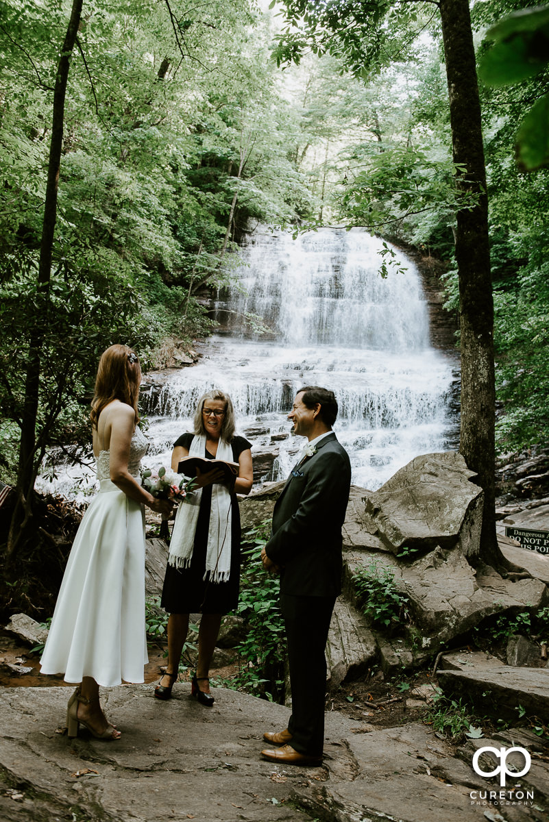 Bride and groom getting married underneath a waterfall at Pearson's falls in Saluda,NC.