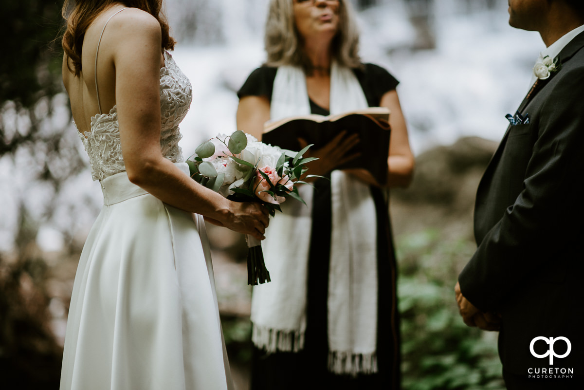 Bride holding a beautiful bouquet in the forest.