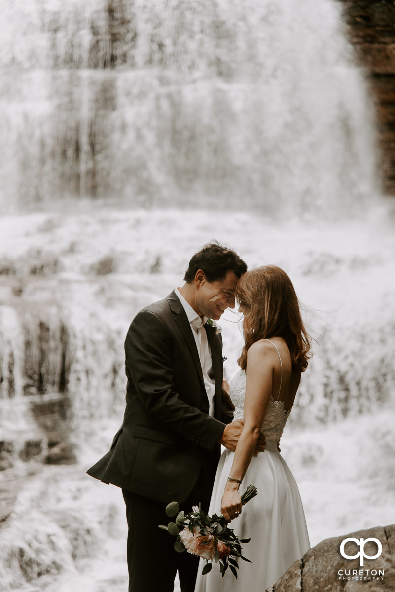 Groom smiling at his bride after their wedding in a waterfall at Pearson's Falls in Saluda North Carolina.