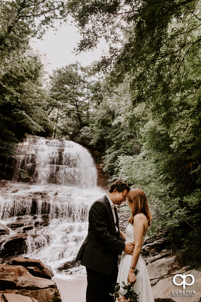 Married couple in front of a waterfall after an elopement wedding.