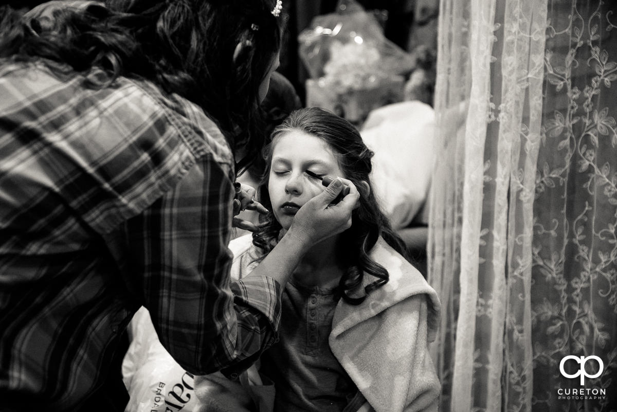 Bride putting makeup on her daughter.