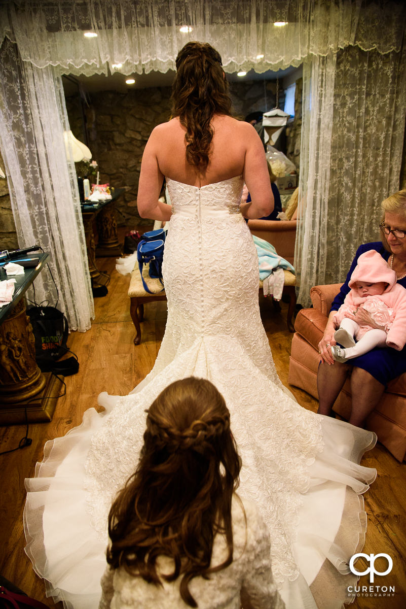 Bride's daughter helping her with her dress.