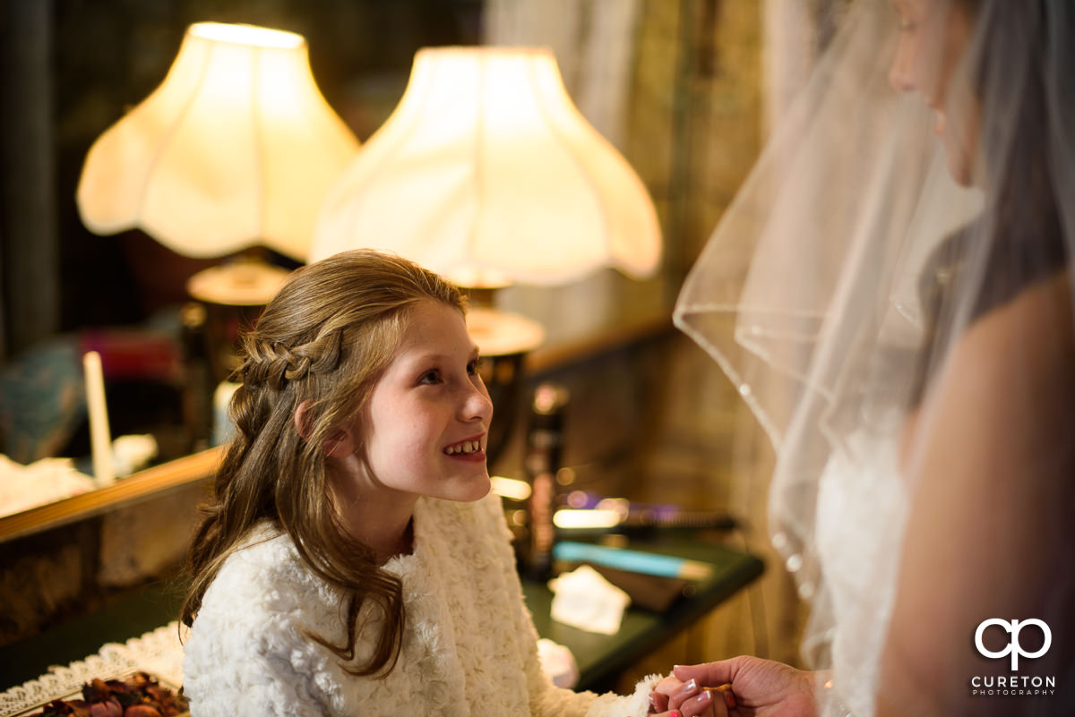 Bride's daughter smiling at her getting ready.