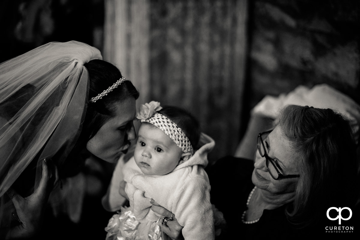Bride kissing her baby daughter.