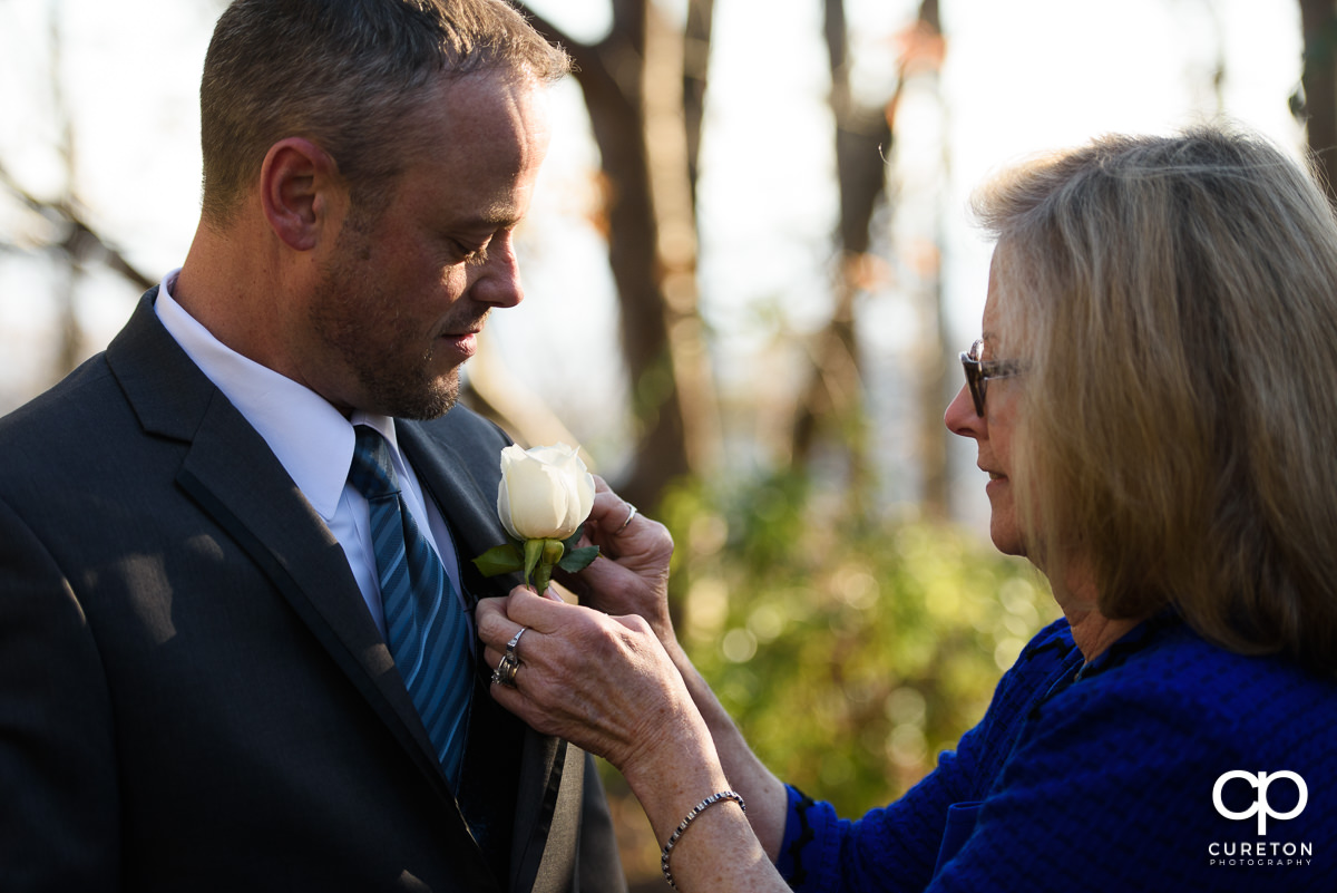 Groom getting his boutonniere on.