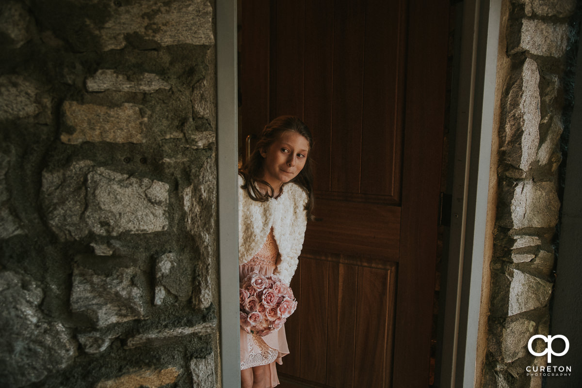 Bride's daughter peeking out of the getting ready room at Pretty Place before the wedding ceremony.