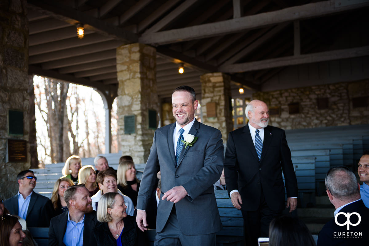 Groom walking down the aisle at Pretty Place laughing.