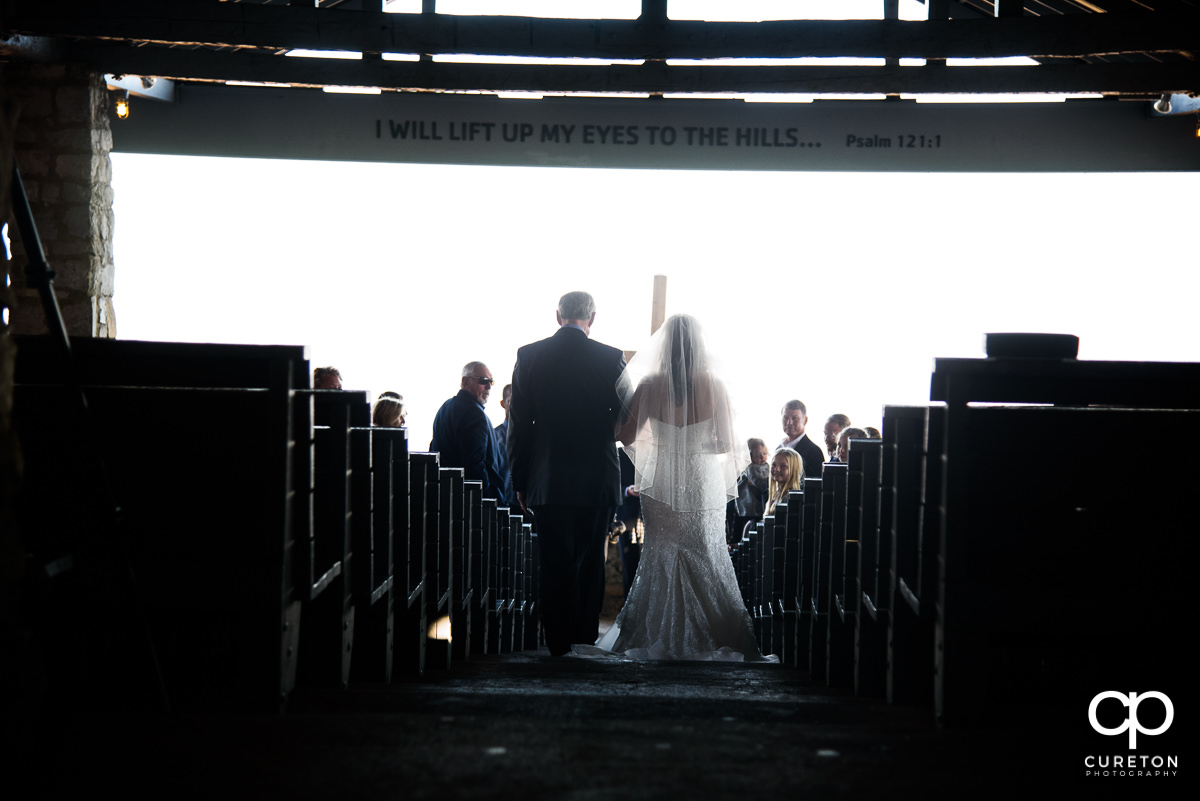 Bride and her dad walking down aisle.