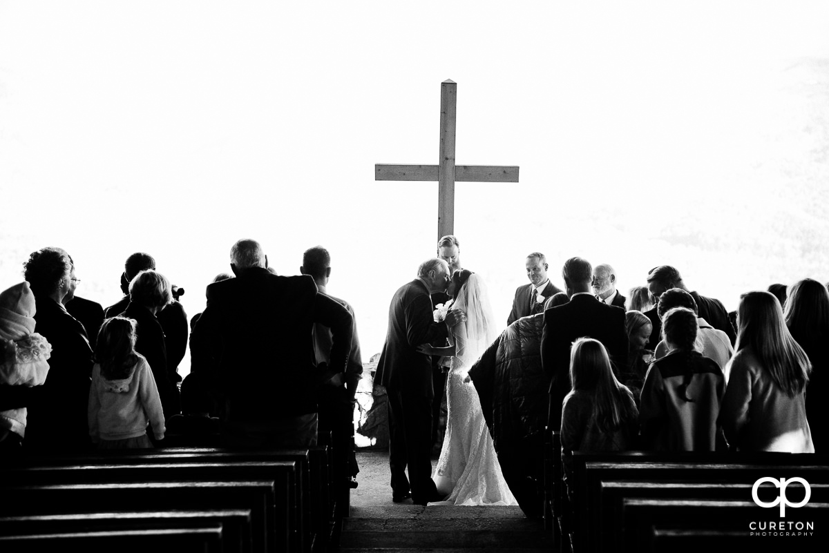Bride's dad giving her away at the wedding ceremony.