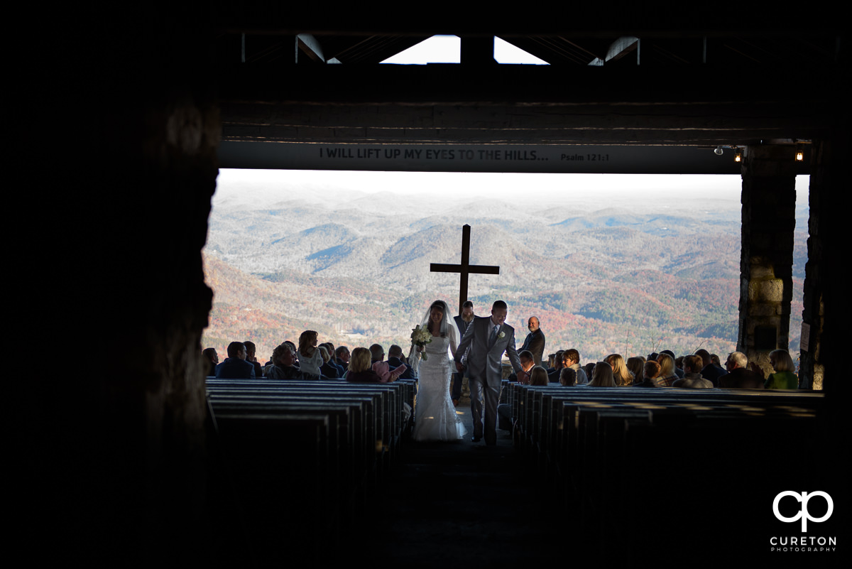 Bride and groom walking back up the aisle.