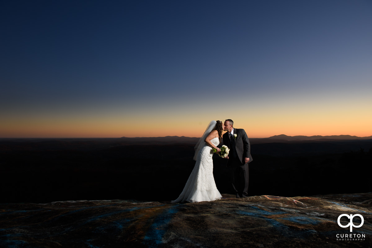 Bride and groom kissing at sunset at Bald Rock.