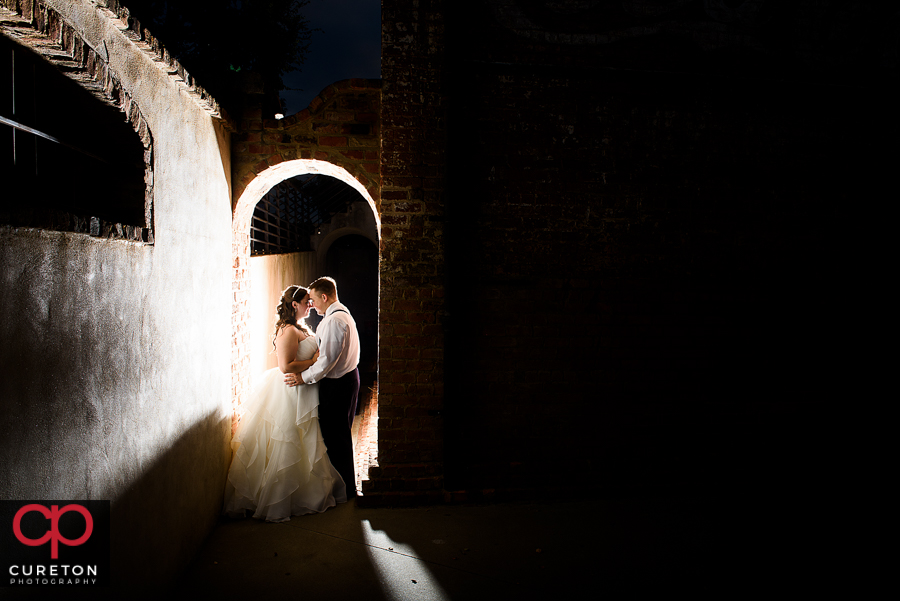 Bride and Groom standing in an archway during their Old Cigar Warehouse wedding reception.