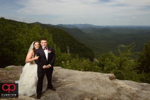 Bride and groom on a cliff after their Pretty Place wedding in the mountains.