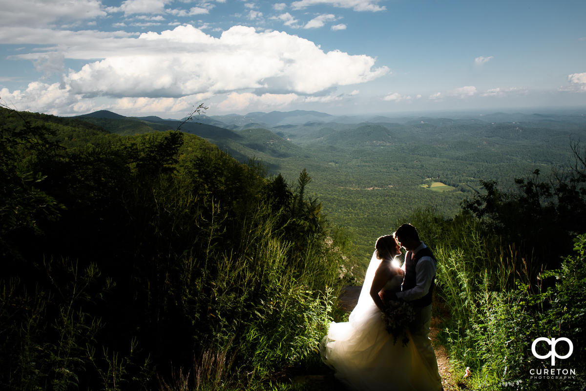 Bride and groom on a cliff after their Pretty Place wedding in the mountains.