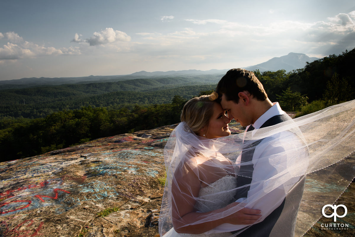Bride and Groom at Bald Rock on a cliff with the veil blowing in the wind.