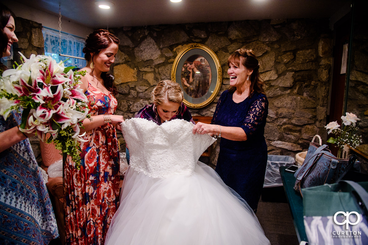 Bride putting on her dress.