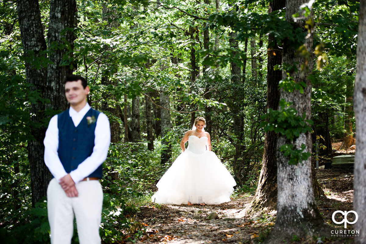Bride walking up behind the groom before their first look at Pretty Place.