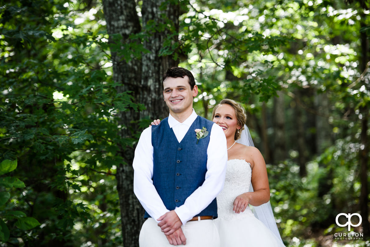 Bride tapping the groom on the shoulder during their first look.